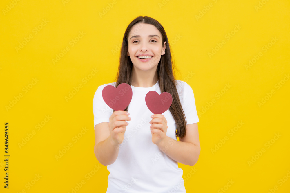 Portrait of pretty smiling woman holding paper heart in her hands on yellow background. Love concept. Valentine day love and beautiful. Portrait of pretty smiling woman holding paper heart in her hands on yellow background. Love concept. Valentine day love and beautiful.