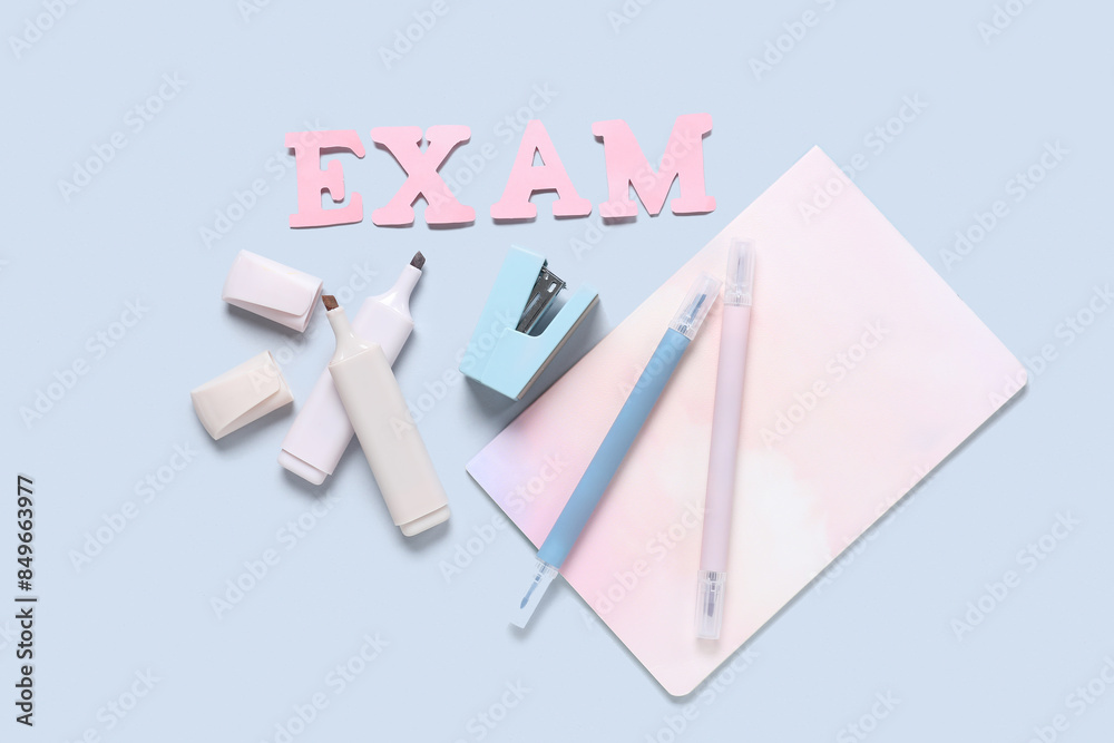 Composition with word EXAM and different stationery on grey background Composition with word EXAM and different stationery on grey background