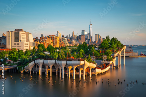 Long exposure of Little Island over the Hudson River in Chelsea, New York, with the lower Manhattan skyline as a stunning backdrop at dusk.