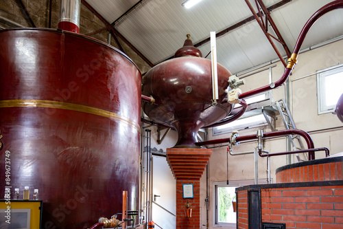 Double distillation process of cognac spirit in Charentias copper alambic still pots and boilers in old distillery in Cognac white wine region, Charente, Segonzac, Grand Champagne, France photo