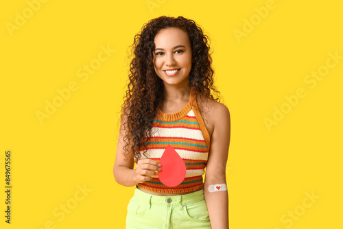 Tableau sur toile Young female African-American donor with paper blood drop and applied medical pa
