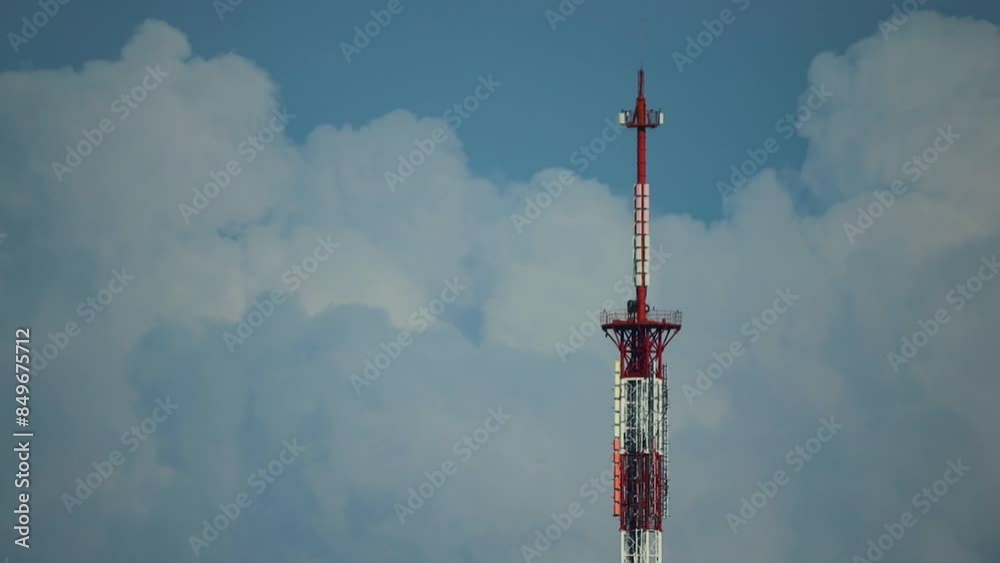 A tall communication tower painted red and white stands against a clear blue sky, emphasizing its towering presence. A tall communication tower painted red and white stands against a clear blue sky, emphasizing its towering presence.