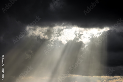 Sunlight beams breaking through clouds, symbolizing hope, clarity, and the triumph over darkness.