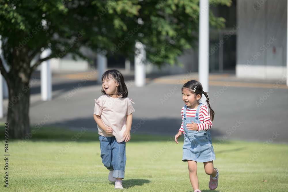 芝生を走る笑顔の子供(幼児)たち　公園や保育園、幼稚園の様子の全身