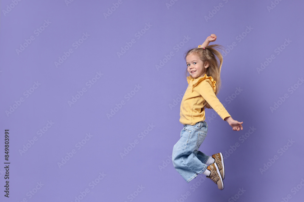 Cute little girl dancing on purple background, space for text Cute little girl dancing on purple background, space for text