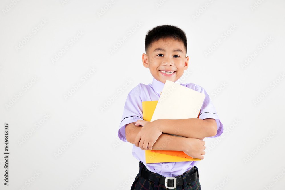 Portrait smile Asian little boy primary posing holding or hugging book studio shot isolated white background, happy cute man kid wear school uniform pride, back to school concept Portrait smile Asian little boy primary posing holding or hugging book studio shot isolated white background, happy cute man kid wear school uniform pride, back to school concept