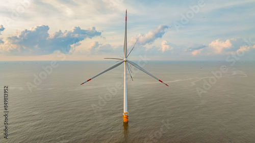 Windmill park with clouds and a blue sky, wind mill turbines in the ocean aerial view of a wind farm in the Ba Dong beach, Tra Vinh, Vietnam production clean energy photo