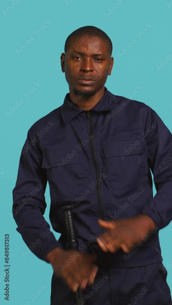 Vertical video Security guard doing time out sign gesturing, being tasked with ceasing unwanted access. Portrait of stern bodyguard showing pause hand gesture, doing interrupting gesture, studio