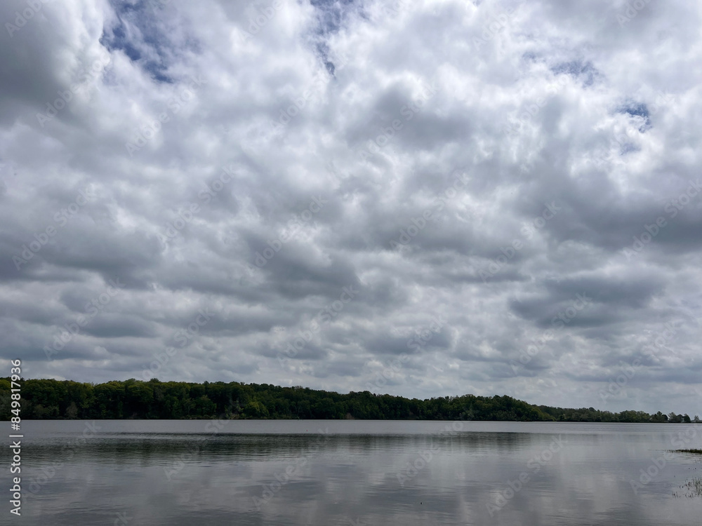 Fototapeta premium Forest lake on a quiet summer morning, clouds over mountain peaks