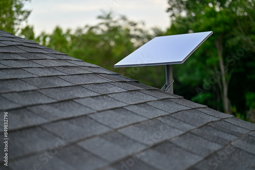 Fotografía Starlink satellite dish with a wall mount on a shingle roof