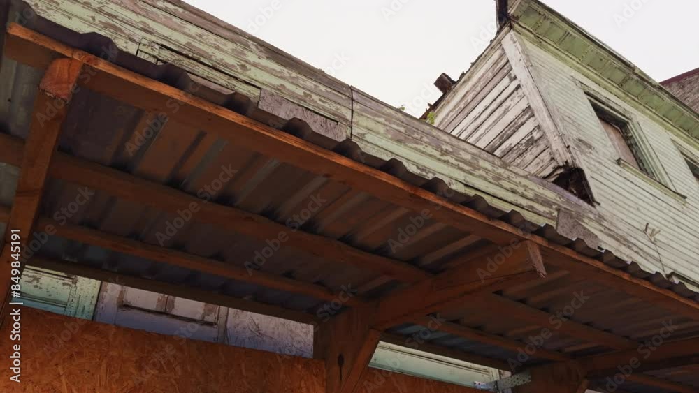 An abandoned building with rusty metal roof and wooden frame shows urban decay in neglected state with weathered and dilapidated look An abandoned building with rusty metal roof and wooden frame shows urban decay in neglected state with weathered and dilapidated look