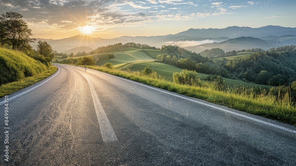 Smooth asphalt road with rolling hills and sunrise in the background Smooth asphalt road with rolling hills and sunrise in the background