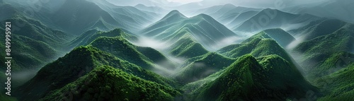 A breathtaking aerial view of mist-covered green mountains creating a serene and mystical landscape in the early morning light. photo