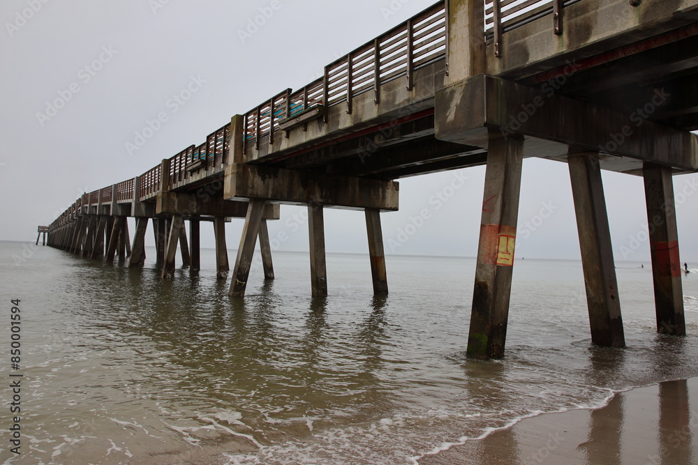 Boardwalk and pier on the beach across the ocean mid-morning. Jacksonville, Florida. Boardwalk and pier on the beach across the ocean mid-morning. Jacksonville, Florida.