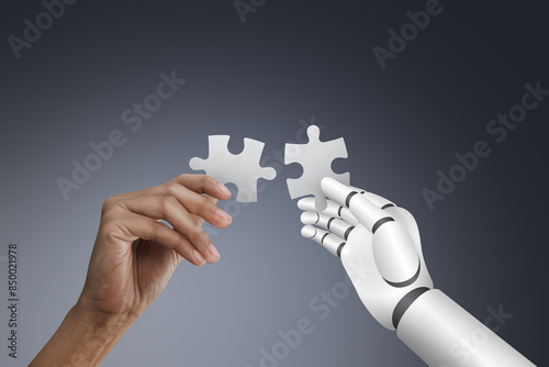 Human hand and Robotic hand holding puzzle on dark background, collaboration and innovation concept.