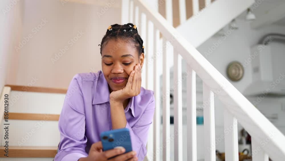 Happy African American young woman texting on her smartphone Happy African American young woman texting on her smartphone