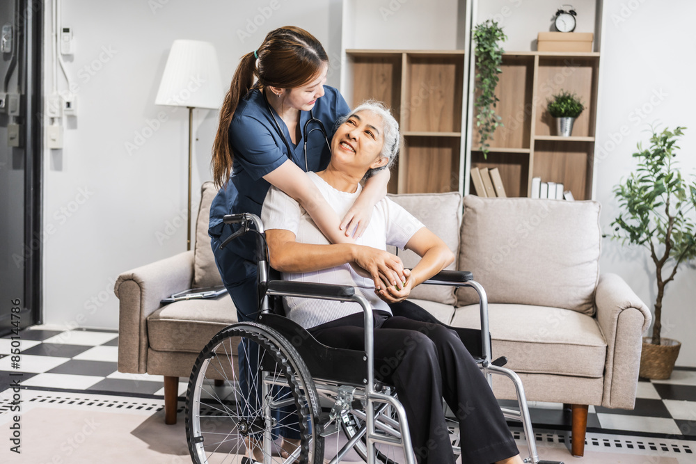A young female nurse of Asian descent assists an elderly woman in a wheelchair, sitting on a sofa. A young female nurse of Asian descent assists an elderly woman in a wheelchair, sitting on a sofa.