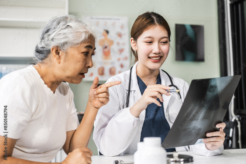 A young Asian female nurse providing healthcare services at her desk, caring for an elderly woman patient. They discuss health checklists and medical advice in a professional setting. A young Asian female nurse providing healthcare services at her desk, caring for an elderly woman patient. They discuss health checklists and medical advice in a professional setting.