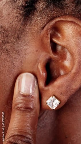 Woman in discomfort covering ear due to painful sound, prompting a visit photo