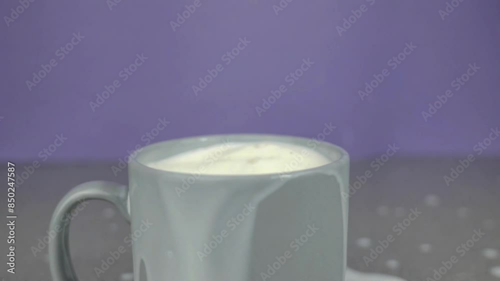 Slow motion of chocolate cookie falling into glass of milk, splash, isolated on purple background, food and drink commercial Slow motion of chocolate cookie falling into glass of milk, splash, isolated on purple background, food and drink commercial