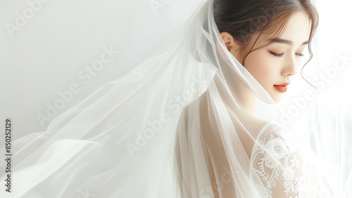 Beautiful bride in flowing lace veil with soft lighting and serene expression