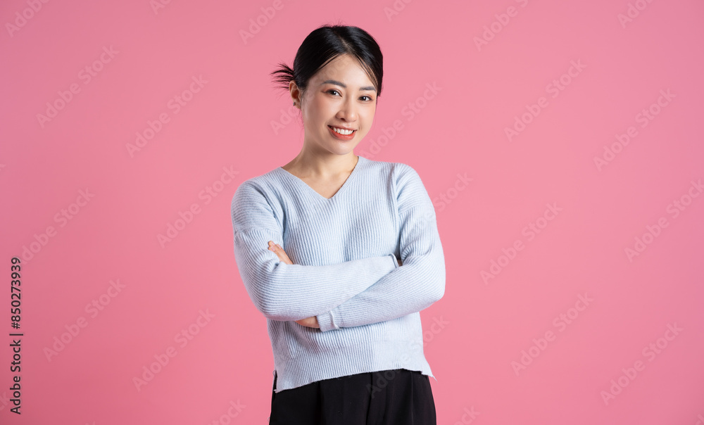 Portrait of beautiful asian woman posing on pink background