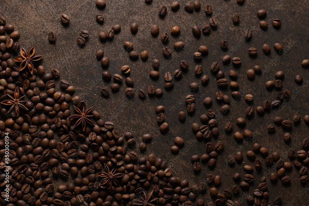 Coffee beans scattered on a textured brown background. View from above. Flat lay Coffee beans scattered on a textured brown background. View from above. Flat lay