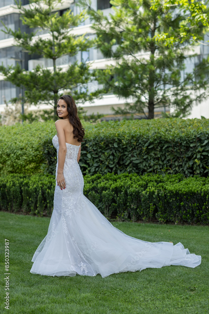 Beautiful young bride in white wedding dress posing outdoor in the park Beautiful young bride in white wedding dress posing outdoor in the park