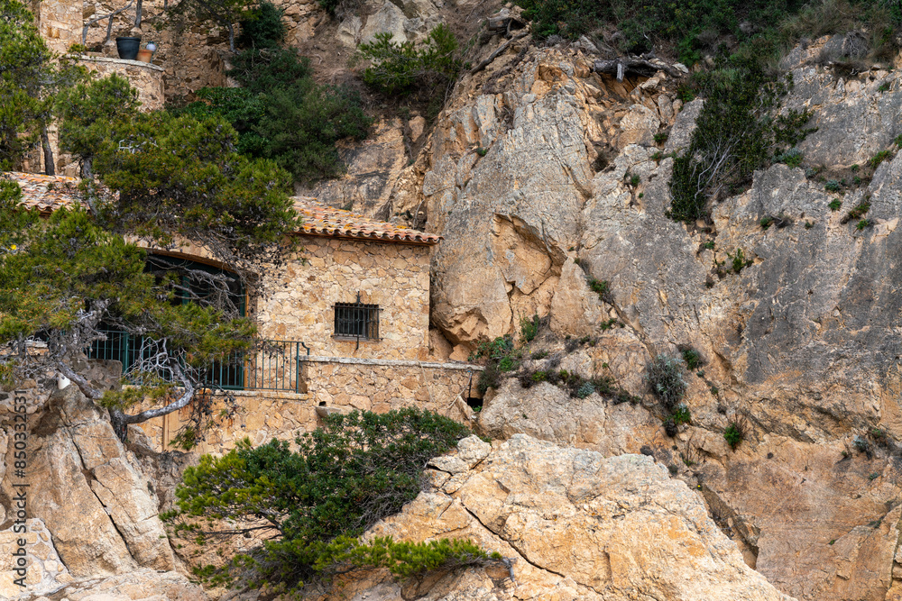 Fototapeta premium Traditional medieval Spanish stone house on the cliffs of the Mediterranean Sea in the Costa Brava region.