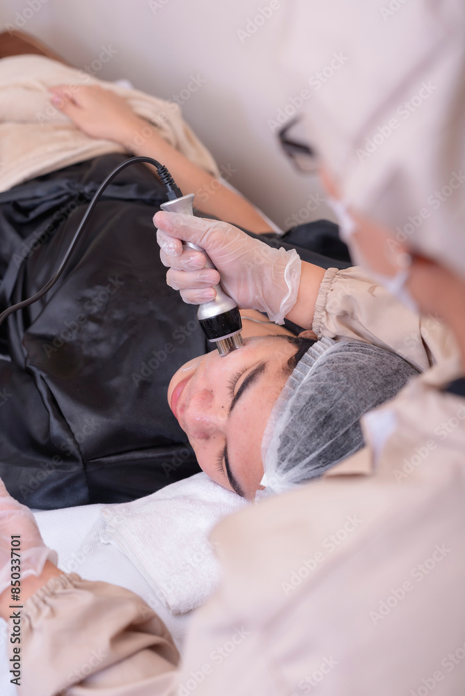 Fototapeta premium Using radiofrequency or RF treatment on the face of a male patient for skin tightening