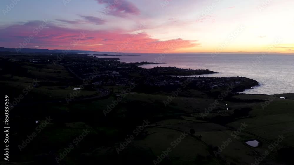 Landscape view of morning sunrise pink clouds ocean coastline over rural town suburbs of Kiama Gerringong South Coast Australia drone aerial travel tourism Landscape view of morning sunrise pink clouds ocean coastline over rural town suburbs of Kiama Gerringong South Coast Australia drone aerial travel tourism