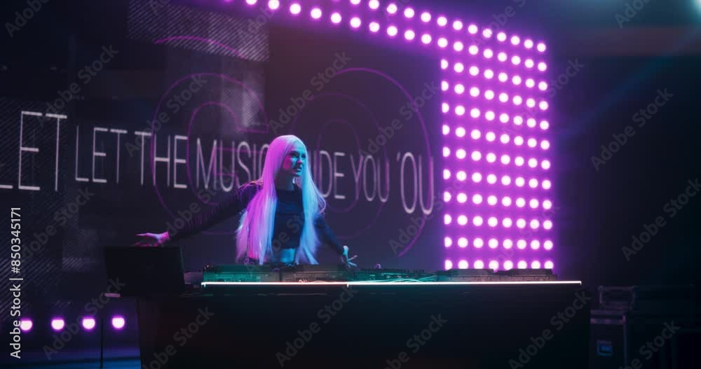 Female DJ Delivers a Mesmerizing Live Performance of Electronic Music with Turntables and Visual Media Art at a Massive Concert. Colorful Lights and Dance Beats Play at an EDM Concert. Slow Motion