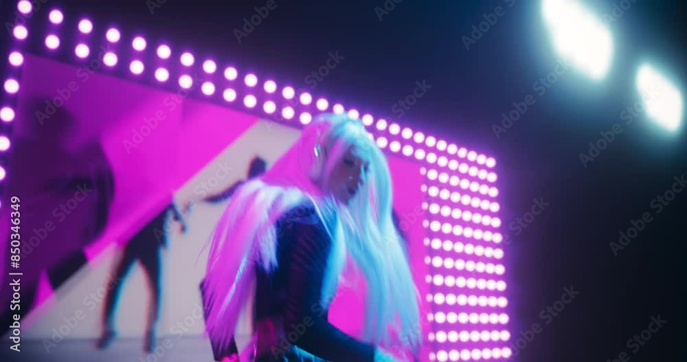 Creative Female DJ Energizing the Nightclub with Her Electronic Dance Music Performance With Colorful Visual Media Art. Pulsating Lights and Beats Create an Energetic Atmosphere in the Club