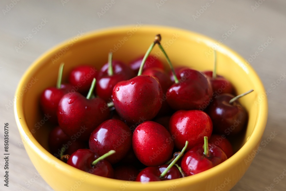 A yellow bowl ceramic with fresh cherries. A yellow bowl ceramic with fresh cherries.