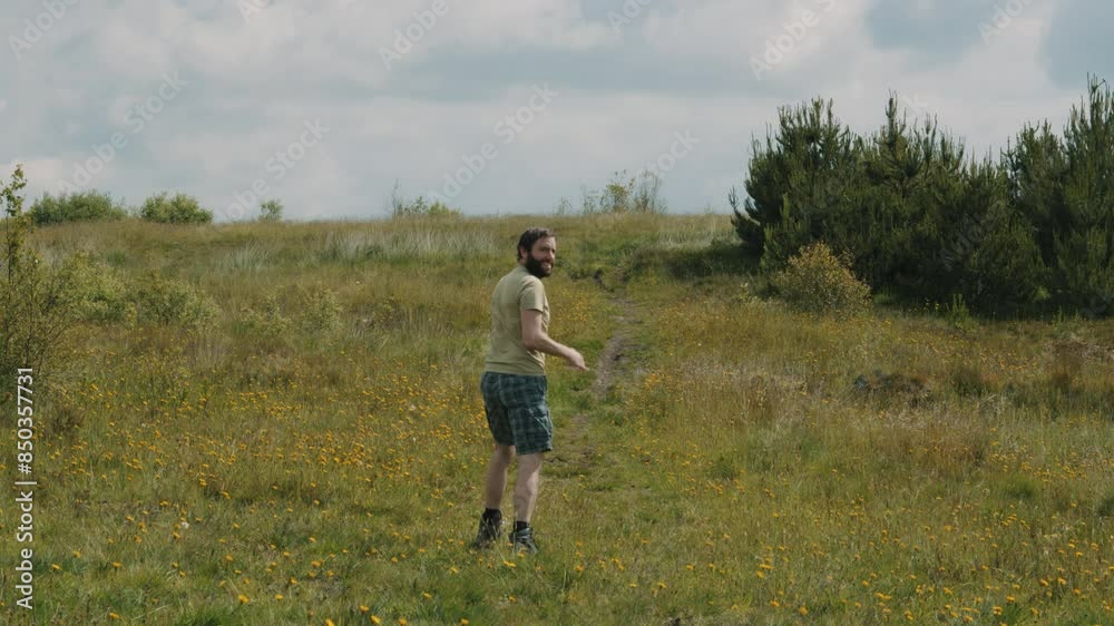 Man Walker Wearing T-Shirt and Shorts Walking in Nature with Long Grass and Bushes Man Walker Wearing T-Shirt and Shorts Walking in Nature with Long Grass and Bushes