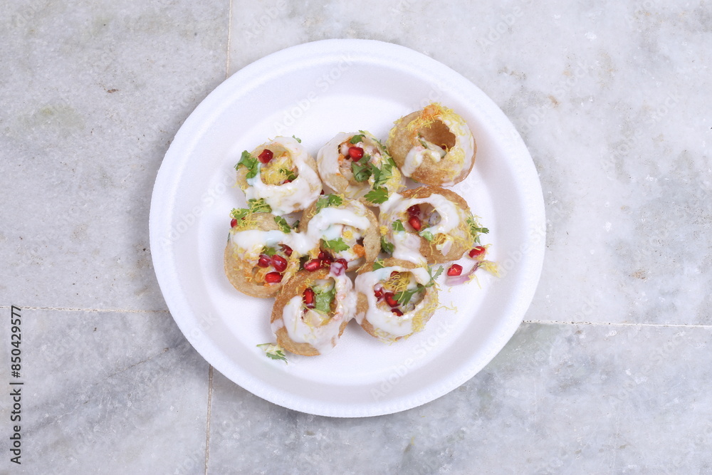 A plate of traditional Indian or Pakistani appetizer Dahi Puri, crispy shells stuffed with boiled potatoes and spices A plate of traditional Indian or Pakistani appetizer Dahi Puri, crispy shells stuffed with boiled potatoes and spices