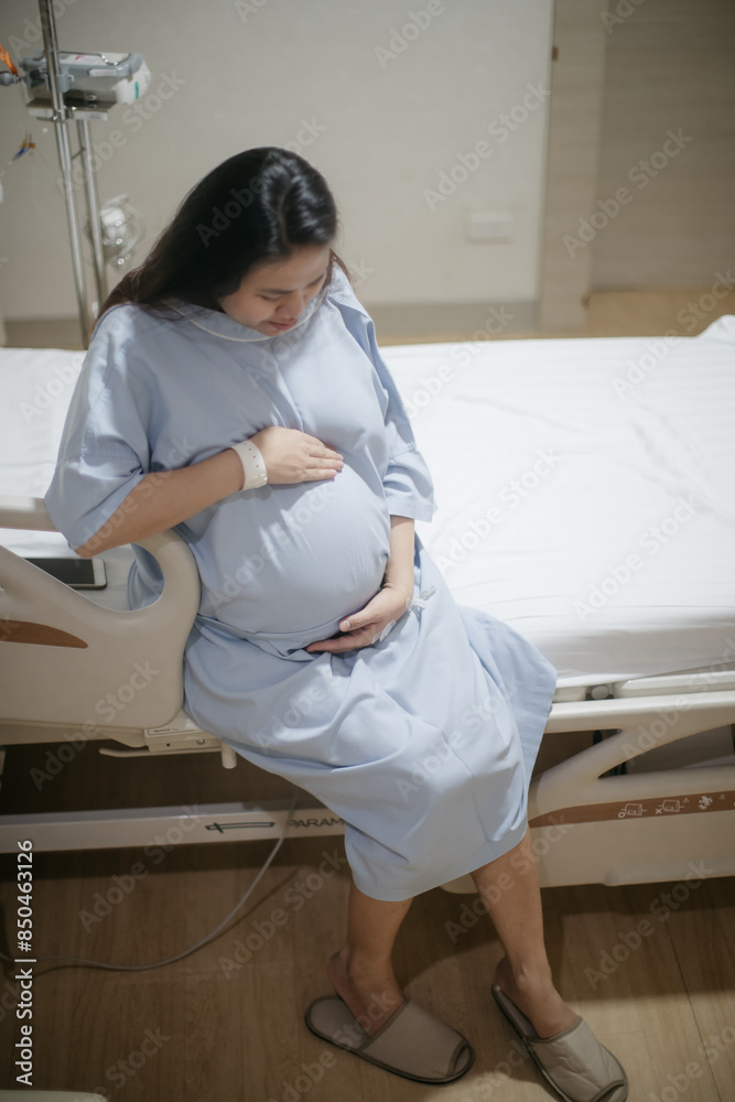 Pregnant Asian woman in a ward getting ready for labour Pregnant Asian woman in a ward getting ready for labour