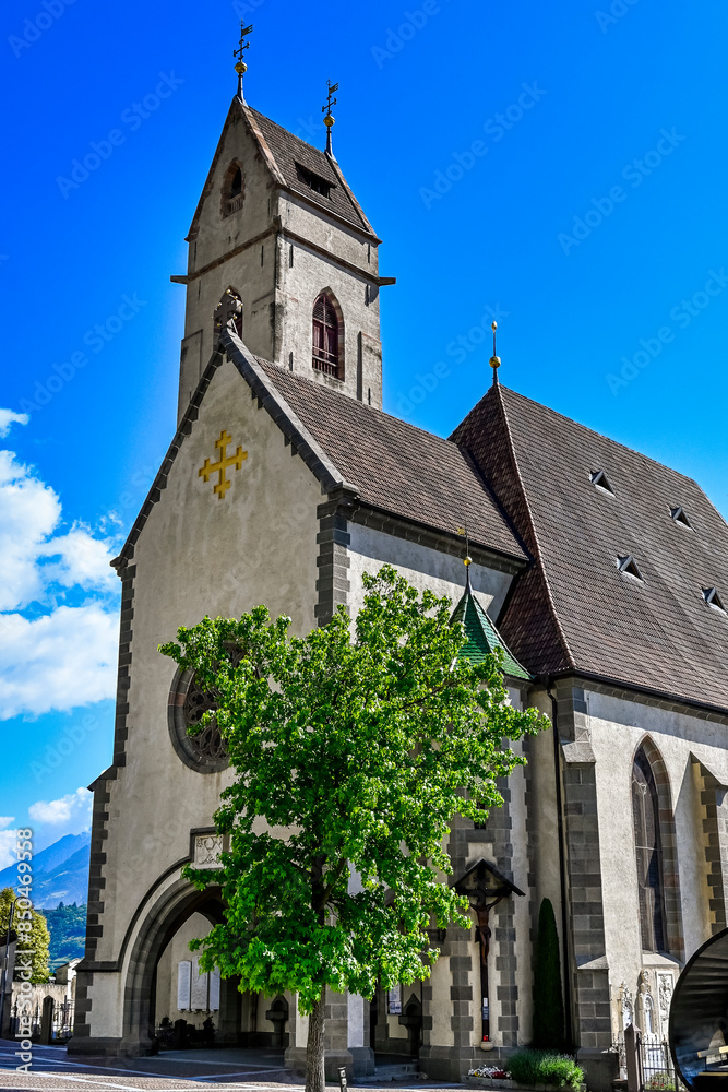 Obraz premium Marling, Marlengo, Dorf, Kirche, Dorfkirche, Kirchplatz, Vinschgau, Etsch, Etschtal, Waalweg, Marlinger Waalweg, Weindorf, Wanderweg, Weinberge, Obstbäume, Meran, Frühling, Sommer, Südtirol, Italien