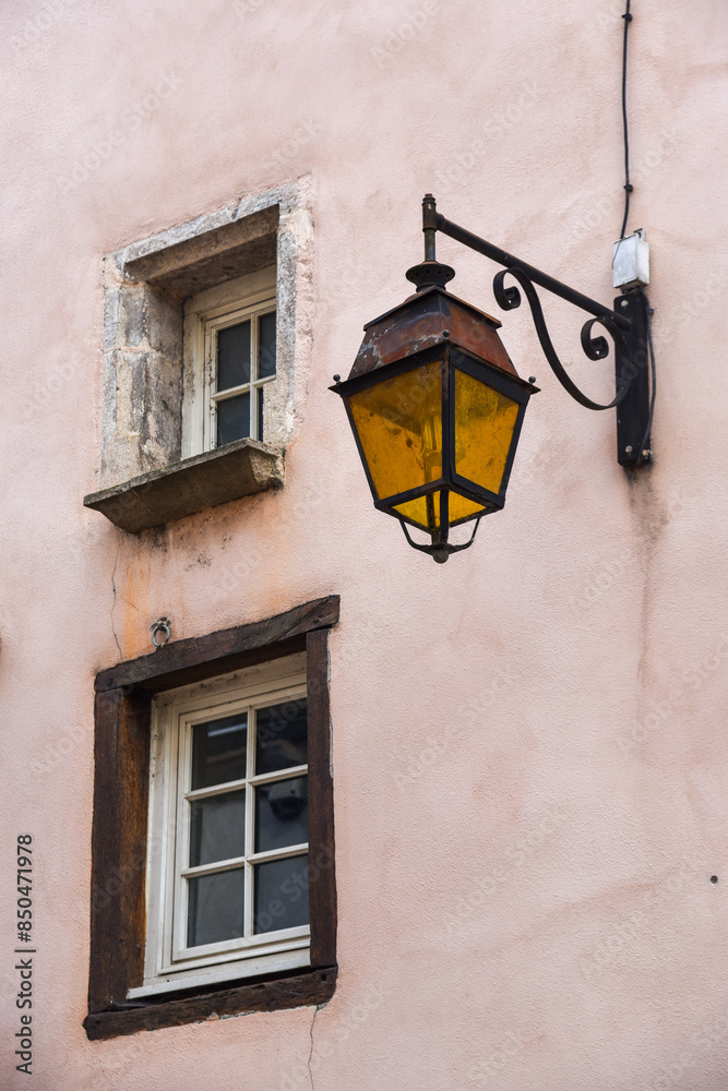 Pink wall with two small windows and a vintage street lamp with yellow glass Pink wall with two small windows and a vintage street lamp with yellow glass