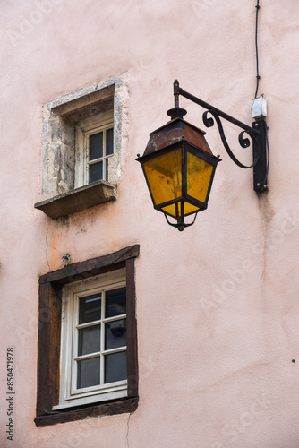 Obraz na płótnie Pink wall with two small windows and a vintage street lamp with yellow glass w salonie