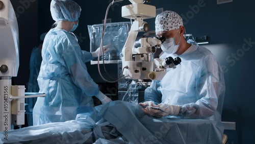 A doctor uses a microscope during eye surgery or diagnosis, cataract treatment and diopter correction. A surgeon looks through a microscope at a patient's eyes in the operating room. photo