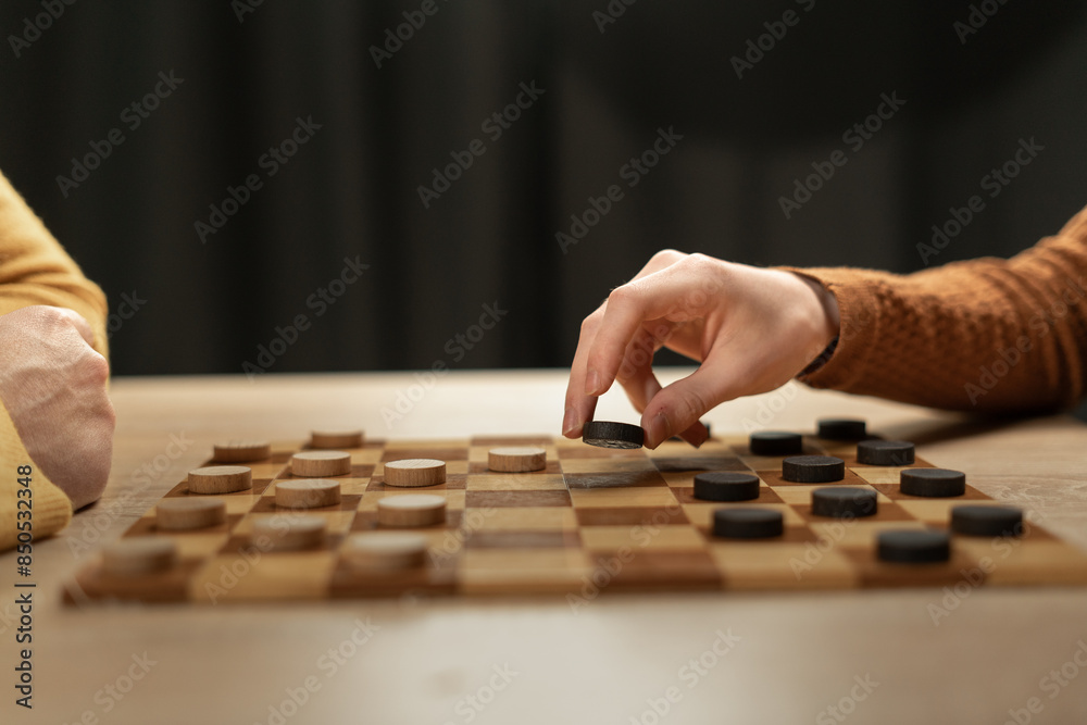 Hands Playing Checkers on Wooden Board, Strategic Game at Home Hands Playing Checkers on Wooden Board, Strategic Game at Home