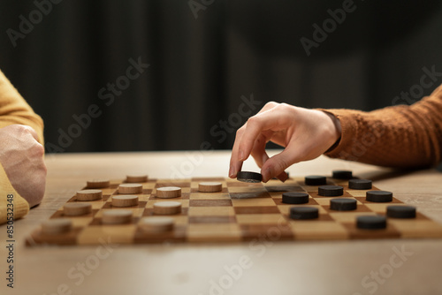 Hands Playing Checkers on Wooden Board, Strategic Game at Home