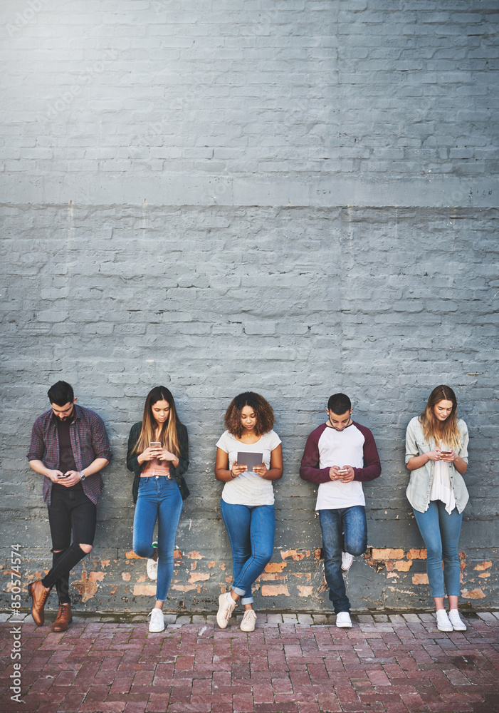 Obraz premium People, row and online outdoor with technology for study break, social media and campus friends. College, students and wall background with texting for communication, digital interaction and search.
