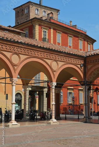 The Basilica of Santa Maria dei Servi stands along Strada Maggiore and is an example of Gothic architecture with the colorful buildings of Bologna around it.