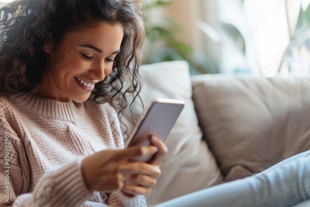 The concept of socializing, using a smartphone for close photos of smiling women, sitting on the couch at home, wearing a casual shirt and jeans, focused on holding the phone screen in hand The concept of socializing, using a smartphone for close photos of smiling women, sitting on the couch at home, wearing a casual shirt and jeans, focused on holding the phone screen in hand