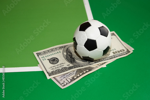 Canvas Print Football ball and dollars on green background, sports betting, bookmaker bets, s