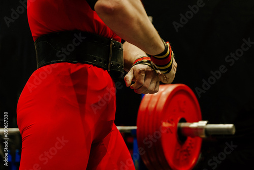 Foto close-up athlete in red singlet on background bench press barbell