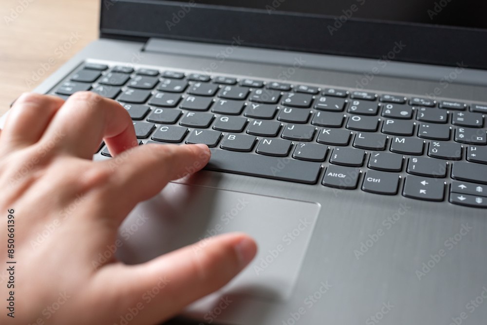 Clavier d'ordinateur portable sur un bureau en bois, main qui tape sur un clavier d'ordinateur Clavier d'ordinateur portable sur un bureau en bois, main qui tape sur un clavier d'ordinateur