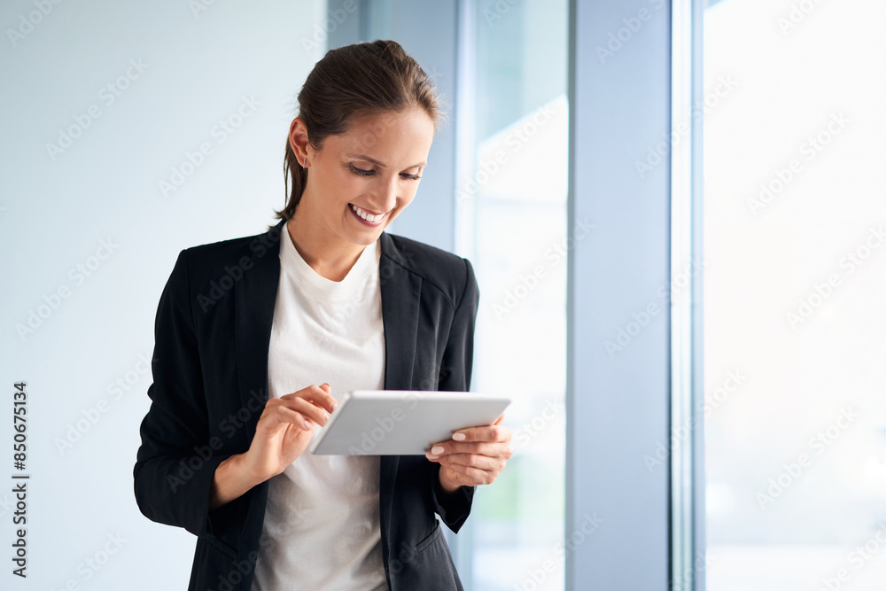 Smiling businesswoman using digital tablet standing in modern office Smiling businesswoman using digital tablet standing in modern office